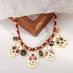 Detail van vintage Halloween fluitketting met suikerschedels en rode kralen op hout