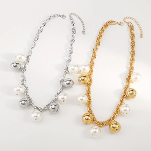 Détail de colliers à maillons épais en or et argent avec perles et boules métalliques