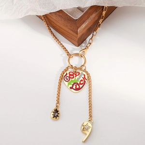 Detail van een gouden hartjesketting met Good Luck gravure en ster-vormige bedeltjes