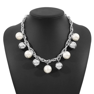 Collier à grosse chaîne argentée avec perles blanches et sphères métalliques sur buste noir