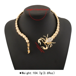 Detail view of bold gold alloy scorpion collar with rhinestones on a black mannequin