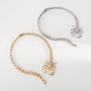 Macro shot of gold and silver scorpion collars with sparkling rhinestone pavé details