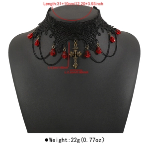 Macro view of gothic black lace choker with red beads and bronze cross pendant