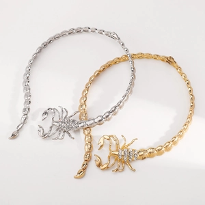 Detailed view of gold and silver scorpion chokers with sparkling rhinestone settings