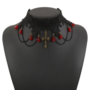 Macro shot of Gothic black lace choker with red crystal drops and bronze cross pendant