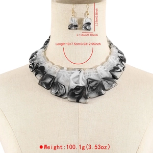 Dettaglio del set di gioielli in resina con motivo marmorizzato bianco e nero su busto