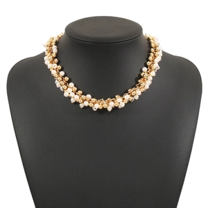 Detail of elegant pearl and gold bead cluster necklace on a black mannequin model