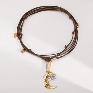 Dettaglio della collana boho intrecciata con ciondolo luna oro e stella d'argento