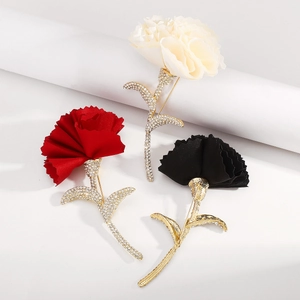Detailed view of elegant fabric carnation brooches with crystal encrusted golden stems
