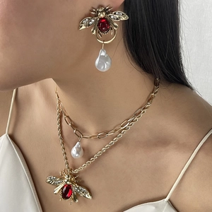 Vintage gold bee jewelry set featuring a pearl necklace and red gemstone earrings