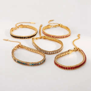 Détail de bracelets gourmettes dorés 14K ornés de zircons colorés et fermoirs mousqueton