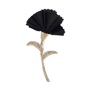 Close-up of black fabric flower brooch with shimmering rhinestones on gold stem