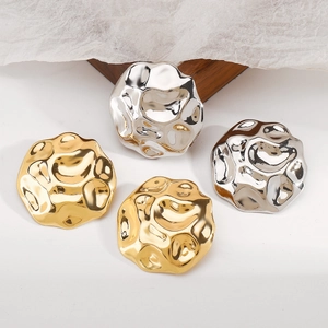 Detail van vintage onregelmatige gehamerde metalen oorbellen in goud en zilver