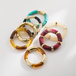 Detailed shot of multi-colored resin bamboo bracelets with polished gold metal sections