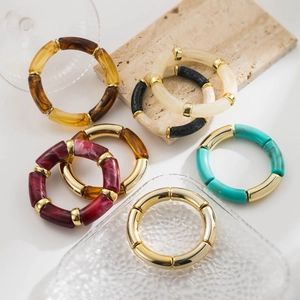 Close-up of bamboo-style elastic bracelets in marble resin and gold metal finishes