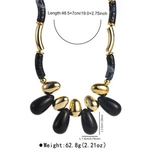Detailed view of vintage chunky acrylic beaded necklace with gold and black marble pendants