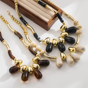 Detailed view of vintage acrylic beaded necklaces with gold metal tubes and teardrop pendants