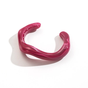 Detail view of wavy magenta acrylic bangle with white marble texture and open design
