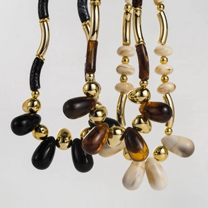 Detailed macro view of retro acrylic beaded necklaces in black amber and cream hues