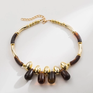 Close-up of retro acrylic beaded necklace with amber resin drops and gold-plated metal spacers