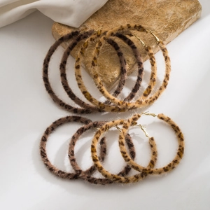 Detailed macro shot of plush leopard print hoop earrings with elegant golden metal hooks