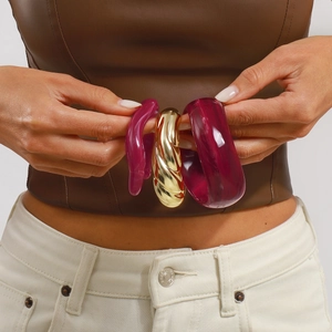 Three-piece bangle set featuring gold twisted metal and dark rose resin bracelets