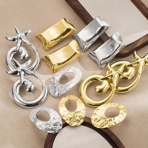 Flat lay of gold and silver earrings in starfish, pillow, and hammered textures