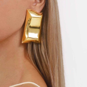 Golden rectangular earrings with crumpled texture and metallic finish shown on model