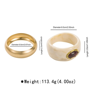 Golden metal bangle set with marbled resin cuff featuring a brown oval gemstone inlay