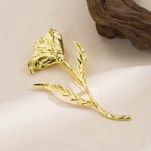 Vintage gold tulip brooch with handcrafted texture on elegant light beige background