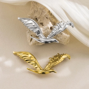 Broches aigle vintage en finitions or et argent avec texture d'aile détaillée sur soie