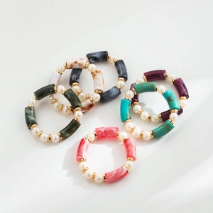 Detalle de pulseras elásticas de resina multicapa con perlas sintéticas y separadores