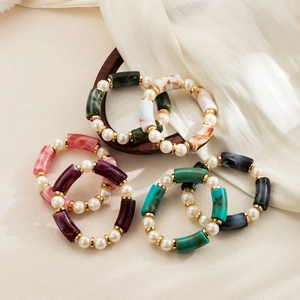 Detalle de pulseras elásticas de resina retro con textura mármol y perlas falsas