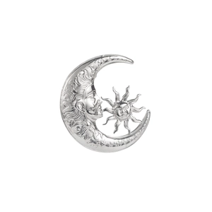 Macro shot of vintage silver sun and crescent moon brooch with detailed facial engraving