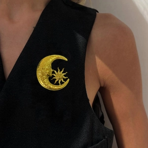 Vintage gold sun and moon brooch pin with mystical facial details on black vest