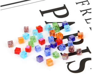 Nahaufnahme bunter 6mm Glasperlen in Würfelform für DIY-Schmuck mit Facettenschliff