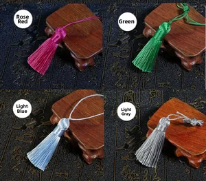 Detailed macro view of handmade silk tassels in rose red, green, light blue and grey