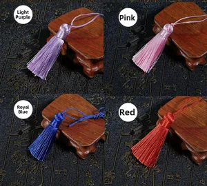 Detail view of handmade silk tassels in purple, pink, blue, and red with traditional motifs