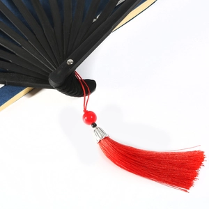Classic Chinese folding fan featuring black bamboo ribs and vibrant red silk tassels