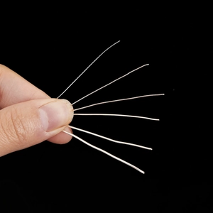 Dunne zilverkleurige flexibele koperdraden voor DIY-sieraden maken in de hand op zwart decor