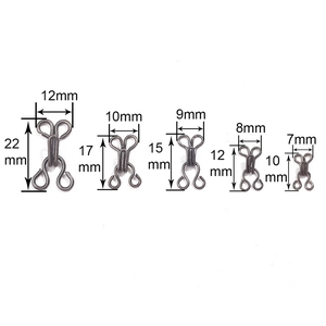 Five sizes of antique silver metal hooks and eyes for bras and trousers on white background