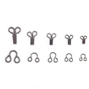 Various sizes of bronze metal hook and eye fasteners for bras and coats on white background