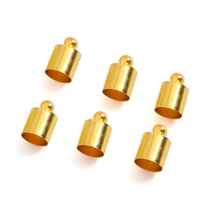 Detailed macro view of six gold-plated copper tassel end caps with rings for DIY jewelry