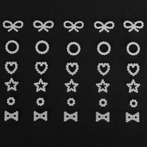 Flat lay of white ABS pearl charms in bow, star, and heart shapes for DIY hair accessories