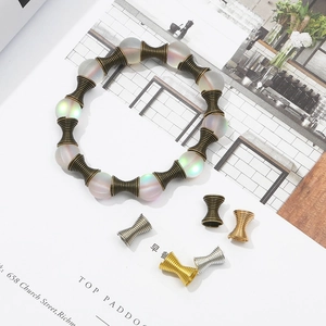 Close-up of DIY colorful frosted beads and bronze spiral metal spacers on a magazine