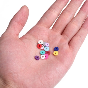 Hand holding 6mm colorful clay heishi beads for DIY jewelry making accessories