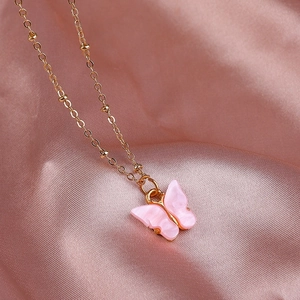 Roze vlinderketting in gouden legering frame met kralen op zachte zijden stof