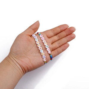Dettaglio di perline colorate con lettere HAPPY e JACKEYLOVE per la creazione di gioielli