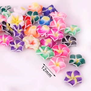Vue macro de perles fleurs frangipanier en pâte polymère 12mm pour bijoux artisanaux