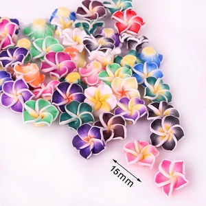 Gros plan de perles fleurs frangipanier en pâte polymère 15mm pour la création de bijoux